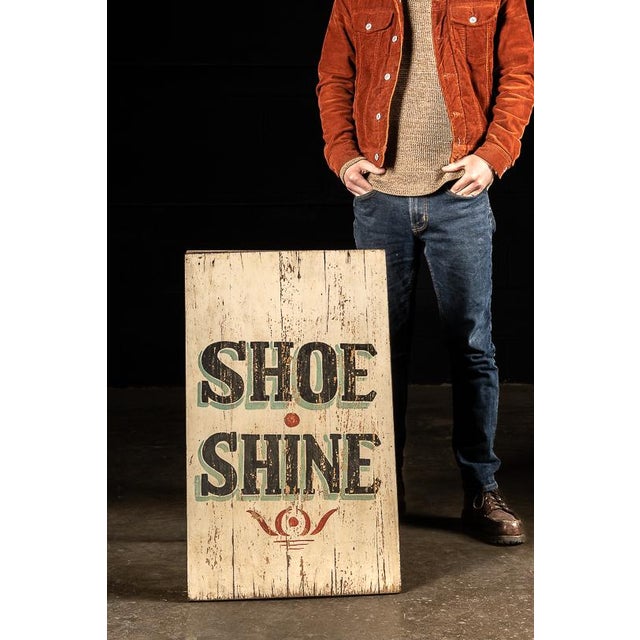 This vintage sign advertises for shoe shining service and would have been prominently displayed on a sidewalk. The sign is...