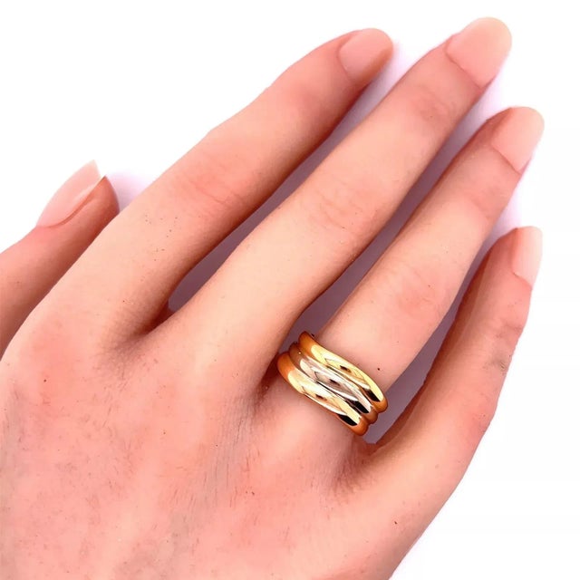 Authentic and elegant by Cartier is a lovely triple stand band ring, crafted from 18k yellow, pink and white gold...