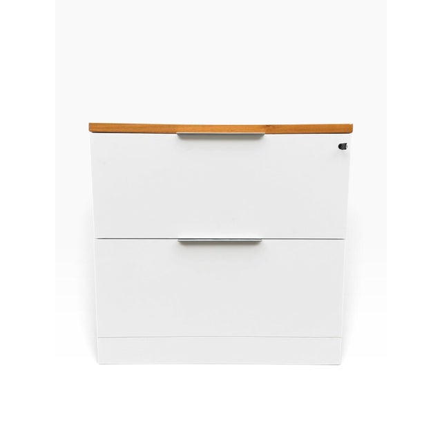 Knoll “Reff Profiles” two-drawer lateral filing cabinet in white, finished with a warm wood-grain top that gives it a...