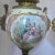 This pair of perfume burners have hand-painted scenes depicting 18th-century romantic scenes and vistas within gilded...