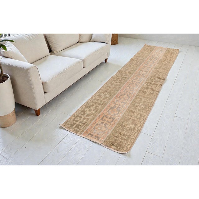 This is a vintage Turkish Oushak rug from the Mid 20th Century. The piece was hand-knotted.