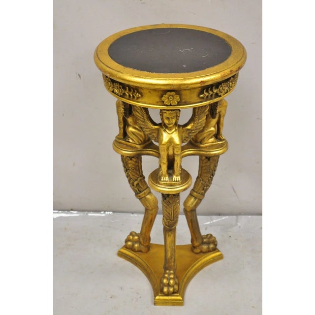 Egyptian Revival Style Gold Giltwood Round Marble Top Figural Pedestal Plant Stand. Item features tripod base with winged...