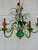 Gold wheat and vibrant greens adorn this lovely chandelier. There is a large metal bow on the bottom portion, I think that...