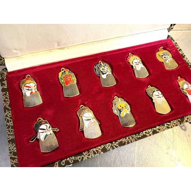 Vintage Chinese Peking enameled opera mask pendants in box; set of 10. Excellent condition. Box measures 10.5" x 5.5" x 1".