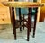 This elegant piece features an intricately engraved circular brass tray resting atop a folding dark wooden stand. It...