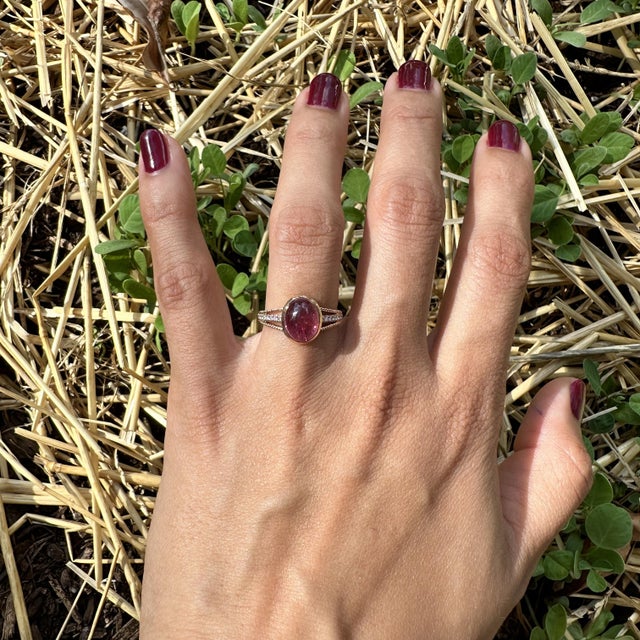 This exquisite cocktail ring showcases a stunning 2.78 carat oval Pink Tourmaline gemstone set in a split shank design...