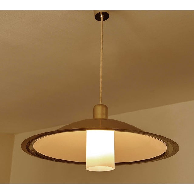 Large Vintage Danish pendant light featuring a semi-sized brass shade, glass shade and white enamel inside the light can...