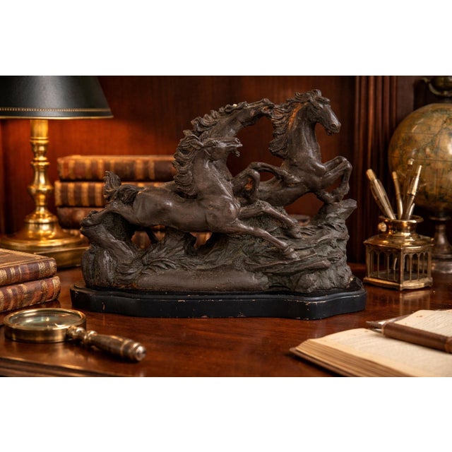 A dynamic vintage sculpture featuring two powerful horses captured mid-motion, rearing and intertwined in a dramatic...