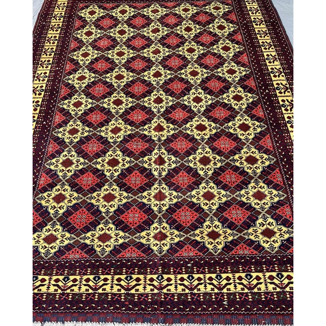 This hand-knotted Afghan Aqcha rug stops a room immediately. The deep burgundy field is organized in a bold star lattice —...