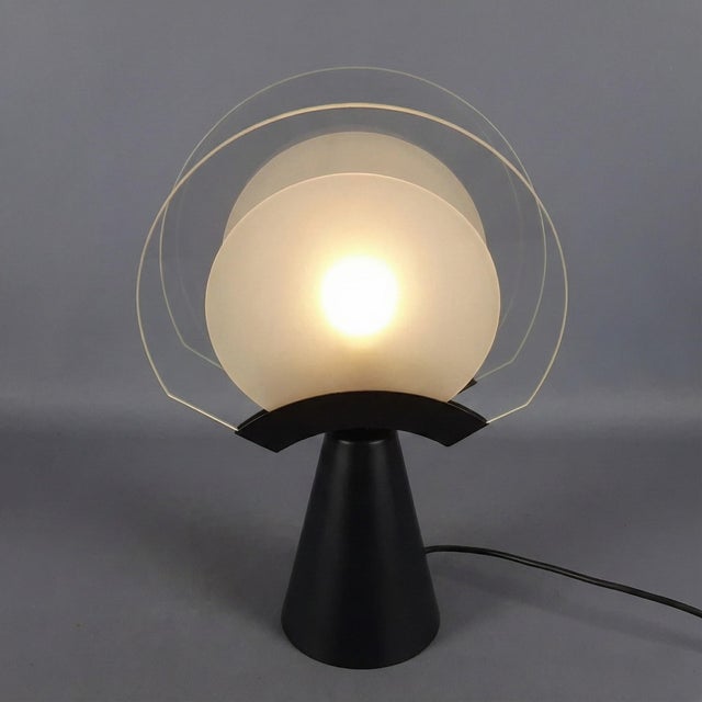 Design and Architecture: The lamp stands out for its architectural construction based on contrasting shapes and materials:...