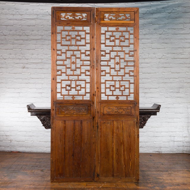 A pair of Chinese Qing Dynasty period large carved architectural panels from the 19th century, with fretwork. Created in...