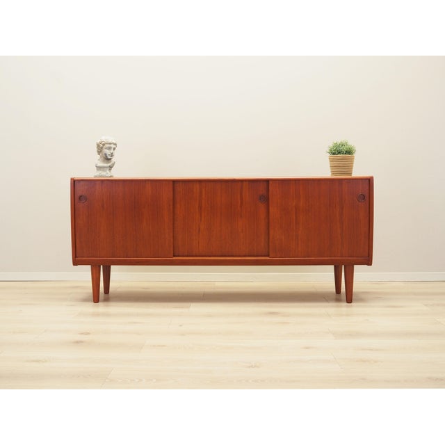 The sideboard was made in the 1970s, Danish production. The structure is covered with teak veneer. The legs are made of...