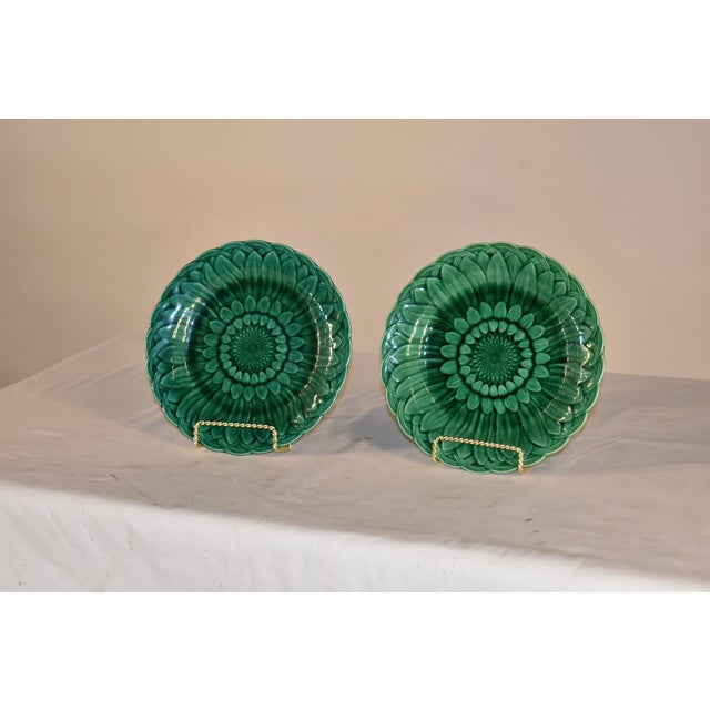 Pair of signed Wedgwood green Majolica plates in the highly collectible sunflower pattern. The plates are in a rich and...