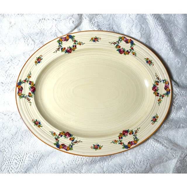The Crown Ducal Oval Serving Platter features intricate floral motifs and embossed patterns. And the orange color trim is...