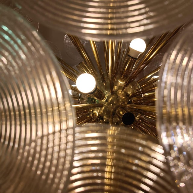 Italian design, Mid Century. Large ceiling lamp with a gilded brass structure and a fixed Sputnik-style bar that...