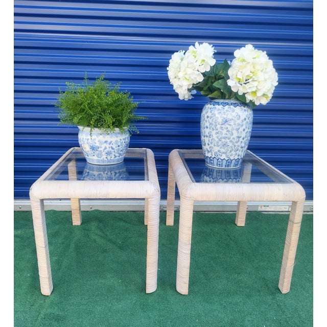 A wonderful pair of vintage rattan wrapped glass top side tables. The tables have a wrapped white wash rattan surround...