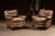 Matching pair of leather club chairs with a relaxed, overstuffed profile and gently rolled arms. Each chair features a...