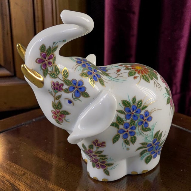 This vintage Lucky Elephant Figurine is a beautifully hand painted and gilded piece made of porcelain. The figurine...