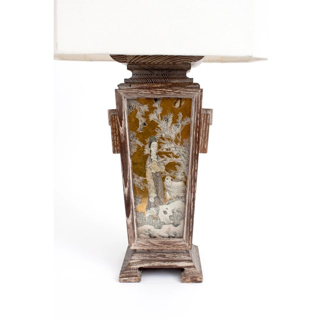 Stunning lamp by James Mont with coursed oak, reverse-painted gilded glass and brass details. Linen octagonal shade. Some...