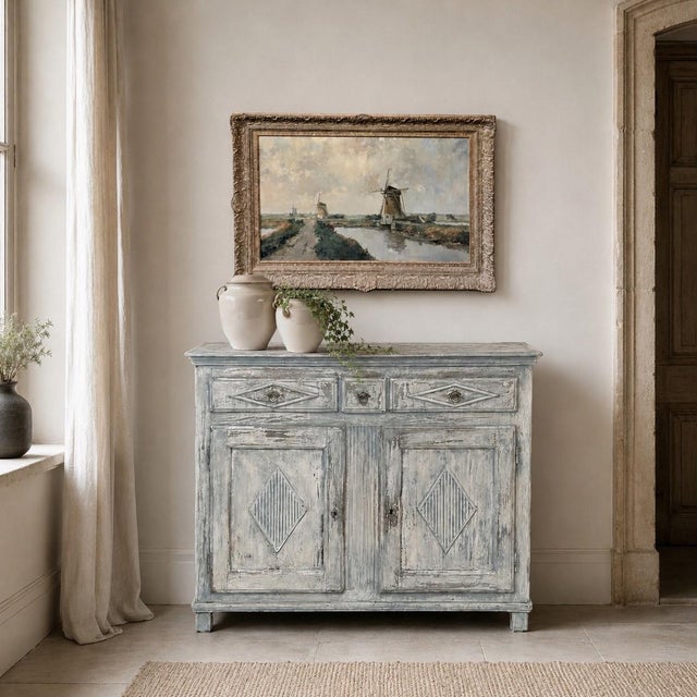 Layers of softly worn pale blue and gray paint give this late 18th century Swedish Gustavian buffet an extraordinary sense...