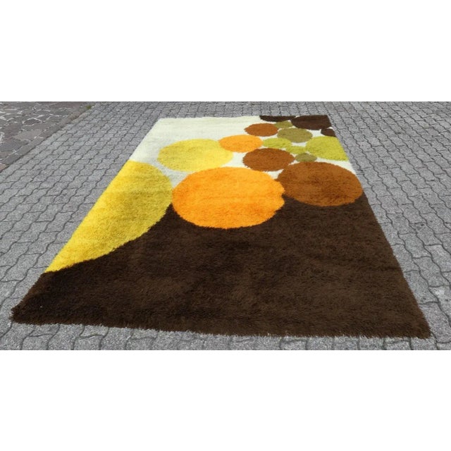 Large long pile wool carpet, with colored circle motifs in shades of orange, yellow and acid green, on a brown and ivory...