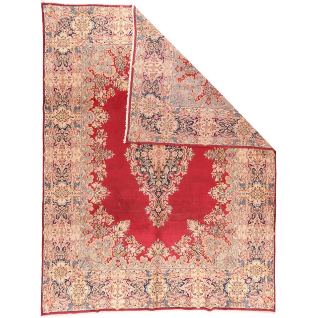 The crimson open field is edged and encroached by a lacy floral surround, while the vertically elongated near black...