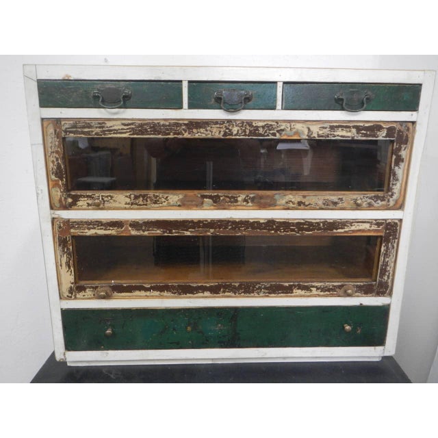 Made of fir wood and lined with reclaimed wood. It features drawers of various sizes. The central drawers have glass...