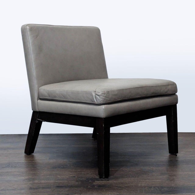 This West Elm lounge chair features a sleek gray leather seat and back with sturdy dark wood legs. Its modern, armless...