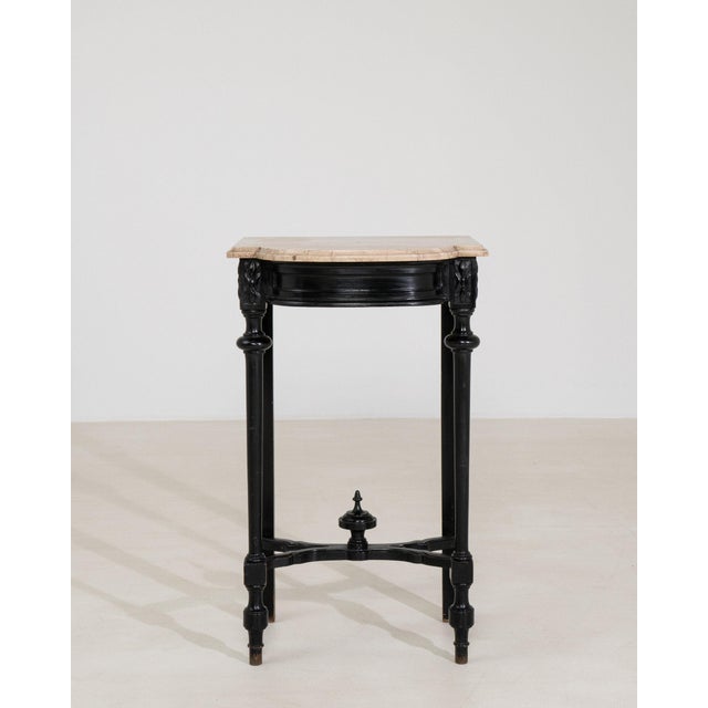 A piece whose travertine top, black carved leaf-motif leg gives it real character at first glance. It was made in France...