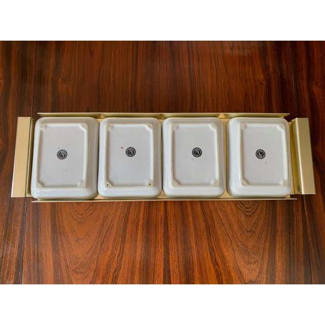 Appetizer tray consisting of four ceramic dishes. Gold metal tray. Printed section of fish on each dish. Fornasetti mark...