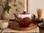 A beautifully sculptural vintage Japanese stoneware teapot featuring a rich chestnut-brown high-gloss glaze accented by a...