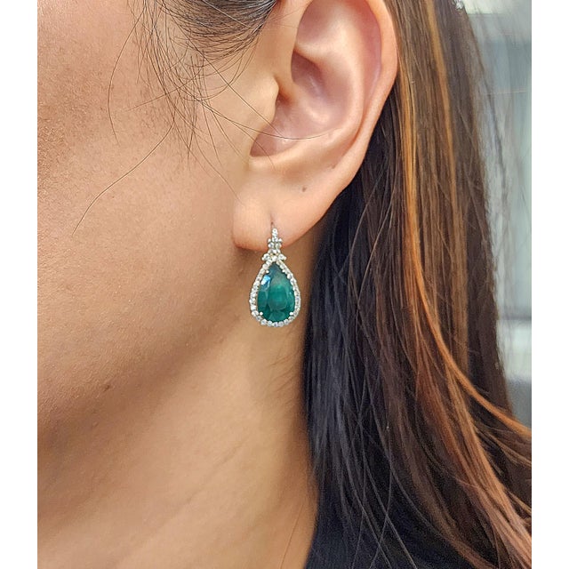 Elegant emerald and diamond earrings featuring 2 natural emeralds totaling 6.22 ct, beautifully complemented by 0.74 ct of...
