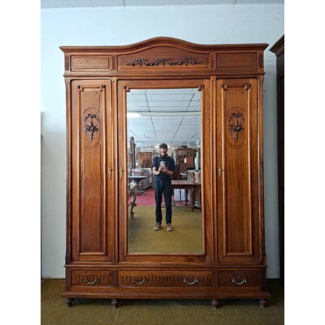 Beautiful Louis XVI style wardrobe in solid mahogany. Opening with three doors, including a central door with a full-...