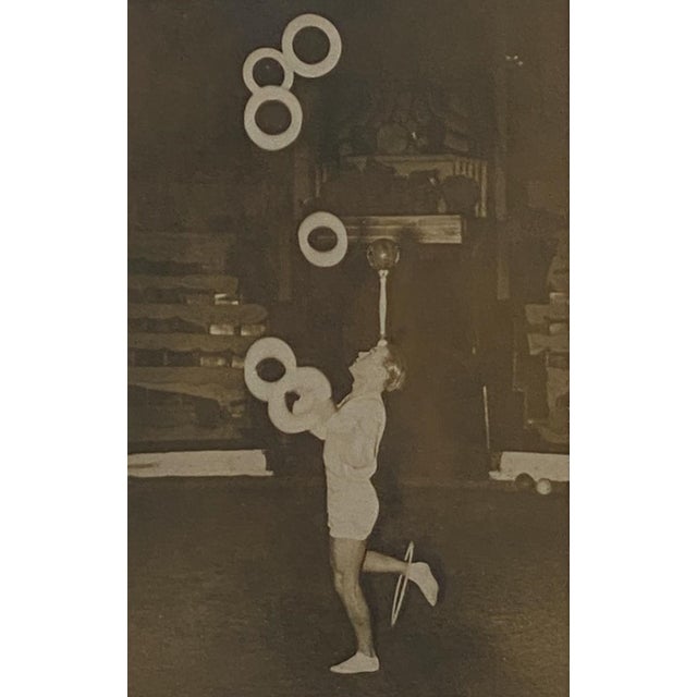 A vintage black and white humorous photograph of a juggler.