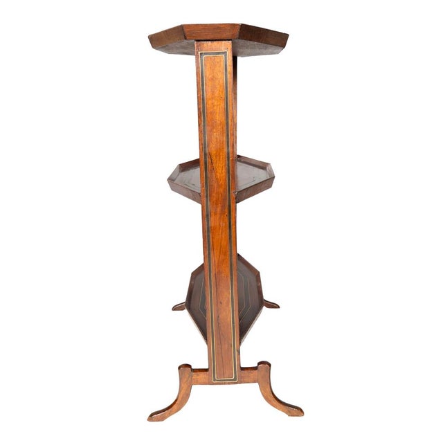 French Directoire mahogany and brass inlaid table. Lozenge shape top with two conforming lower shelves. Saber legs.