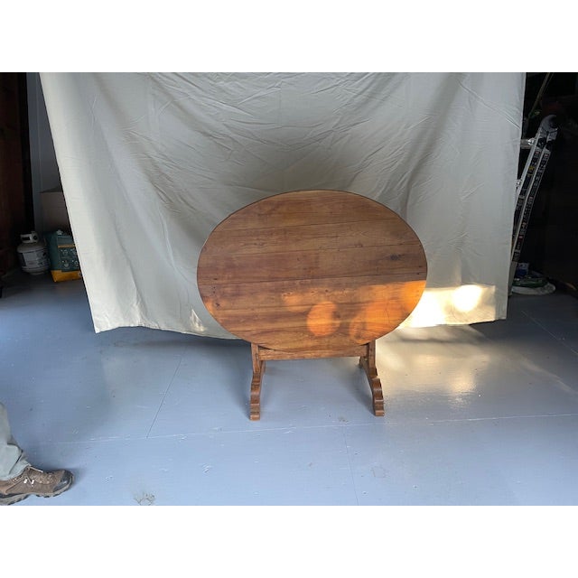 This is a 19th century French oval fruitwood wine tasting table from the region of Provence. The dimensions are as...