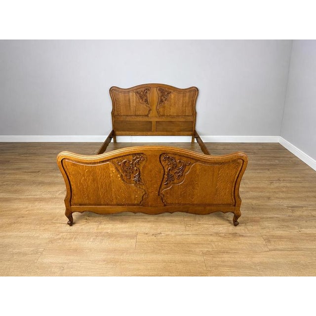 An elegant Vintage French Louis double bed featuring a beautifully shaped headboard and footboard, decorative carved...