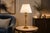 A tall and elegant vintage table lamp inspired by classical empire and neoclassical design, featuring a polished brass...