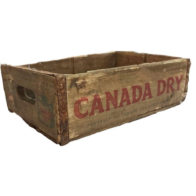 Bring a touch of nostalgic Americana into your home with this authentic, mid-20th-century Canada Dry wooden beverage...