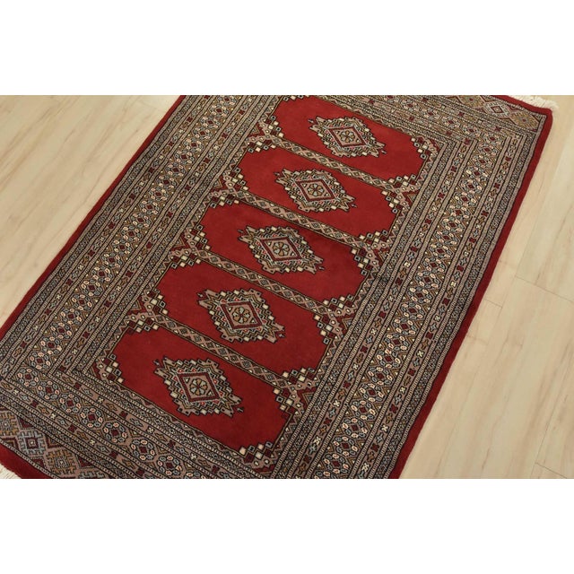 A tribal Bokhara Jaldar rug hand-knotted with fine wool on a cotton foundation. This rug features geometric medallions set...