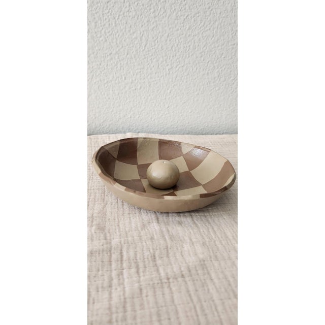 This is a handmade clay incense burner featuring a distinctive checkered pattern in contrasting earthy tones of brown and...
