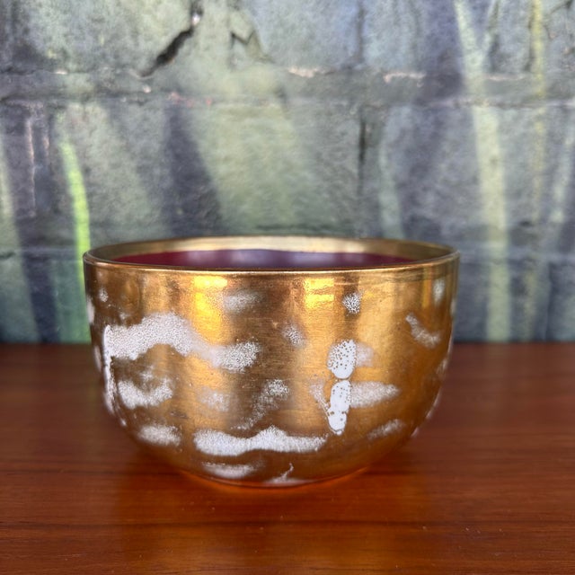 This is a gorgeous, gold bowl made by Waylande Gregory. The exterior is covered in a metallic gold finish with clouds of...