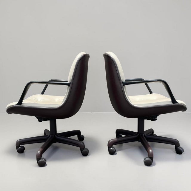 Pair of vintage Steelcase executive office chairs, Pollock style. These chairs have the a cream vinyl faux leather, tufted...