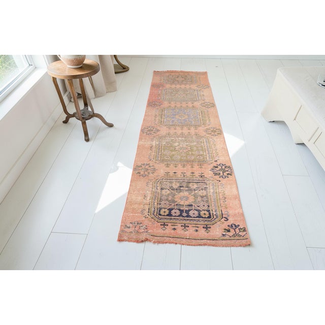 This is a vintage Turkish Oushak rug from the Mid 20th Century. The piece was hand-knotted.