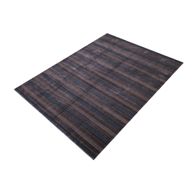 Decorate your living space with this beautiful hand-knotted rug. Featuring a two-tone color pattern, this rug adds a...