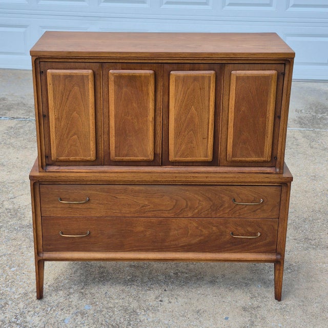 This is a mid century modern highboy chest of drawers attributed to Broyhill, circa 1960s. The original brass label is...