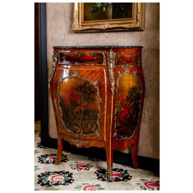 An elegant antique French cabinet crafted in the Vernis Martin tradition, featuring hand-painted pastoral landscape panels...