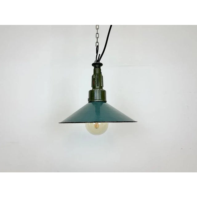 Industrial petrol enamel pendant light made in Poland during the 1960s. White enamel inside the shade. Green cast...