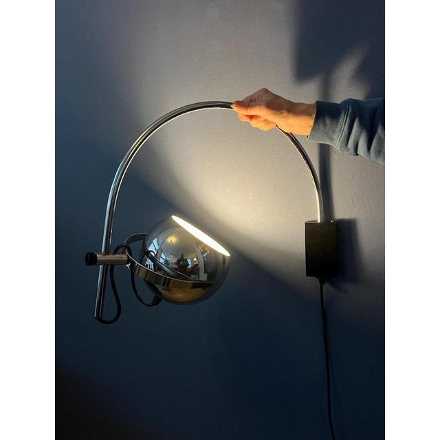 Space age eyeball arc wall lamp by Herda. The chrome shades can be positioned inside or outside the arc and be turned in...