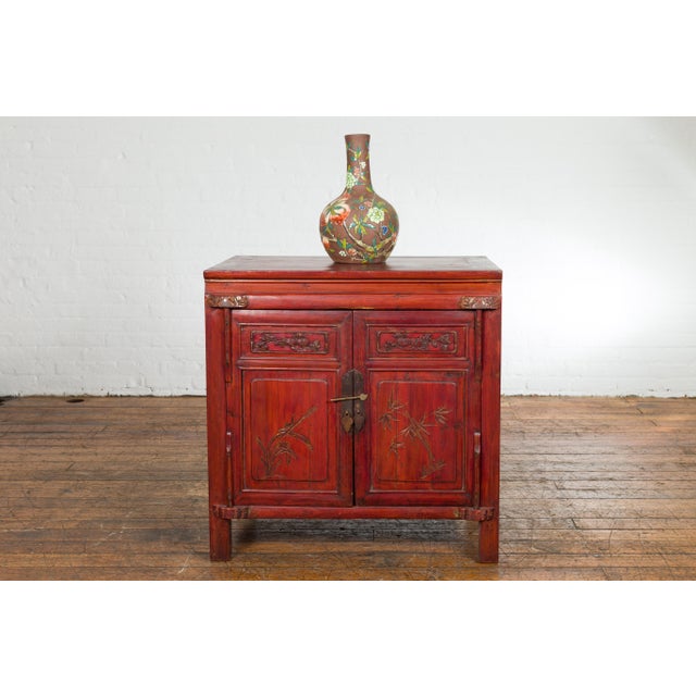 A small Chinese red lacquered wedding blanket chest from the 20th century, with gilt décor depicting guardian lions,...